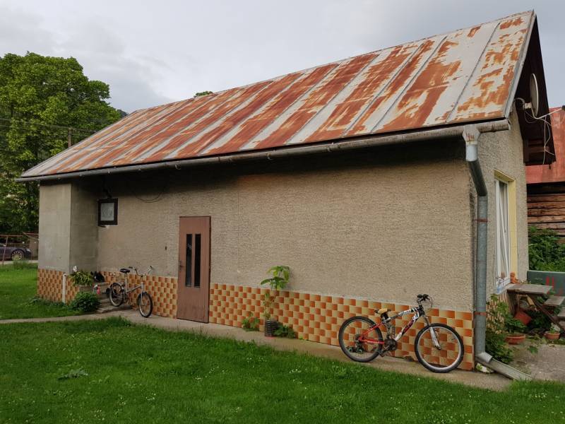 PREDAJ – Rodinný dom s druhou samostatnou stavbou, garážou  - Rodinný dom v Blatnici na Blatnici s plechovou strechou a bicyklami v záhrade.