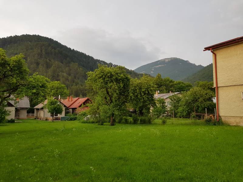 PREDAJ – Rodinný dom s druhou samostatnou stavbou, garážou  - Rodinný dom v Blatnici obklopený zelenými stromami a pohorím.