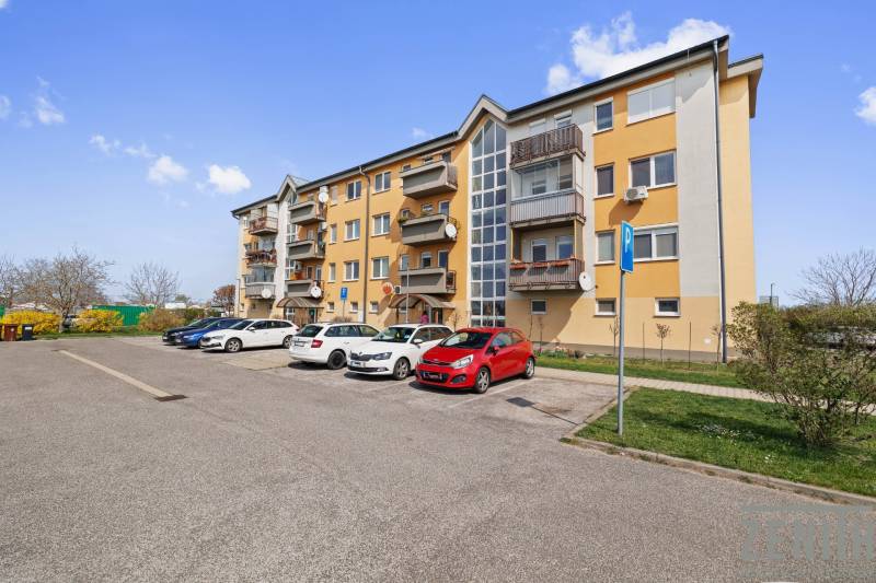 Veľký 2-izbový byt so súkromnou záhradou a balkónom – Most pri BA - Obytná budova s balkónmi a parkoviskom na ulici M. R. Štefánika v Moste pri Bratislave.