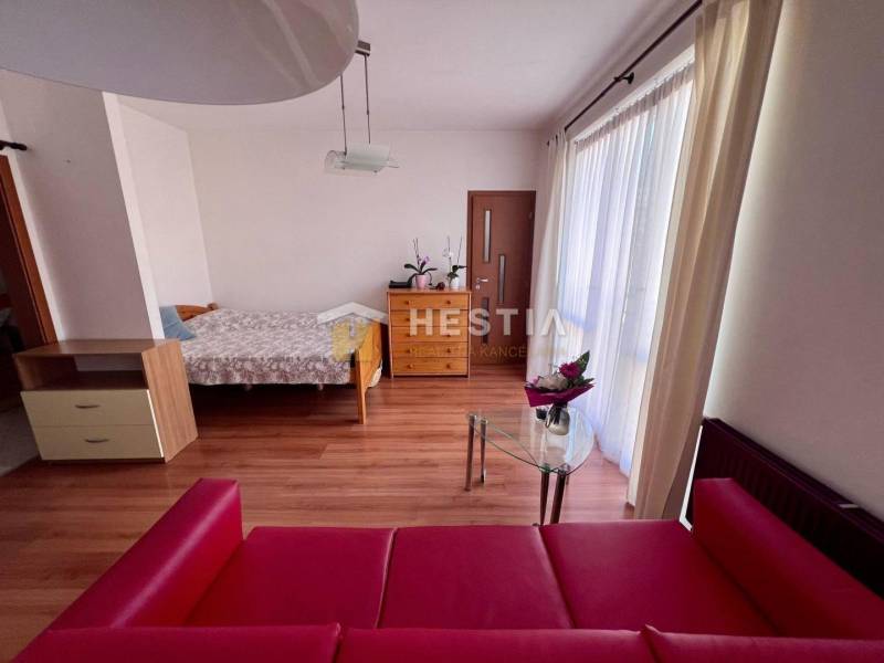 Štýlový 1 izbový byt v Piešťanoch s balkónom, vo výbornej lokalite - Na fotografii je 1-izbový byt, zahŕňajúci posteľ, červenú pohovku a sklenený stôl.