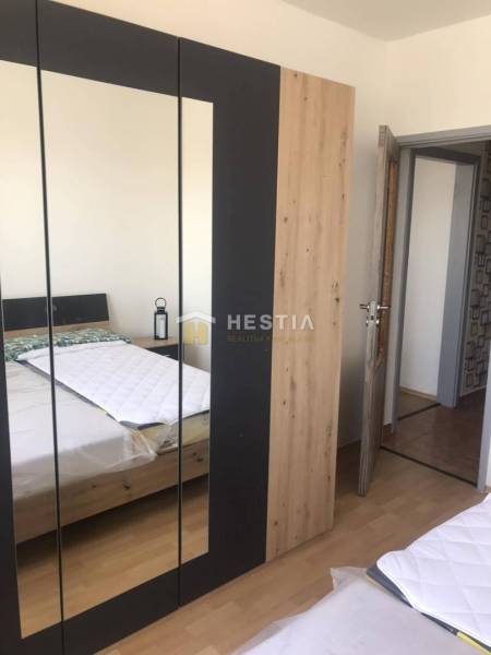 NOVINKA Prenájom 2 izbového bytu na Robotníckej ulici, voľný od 01.05. - Spálňa s posteľou, skriňou a podlahou s dreveným dekorom v 2-izbovom byte.