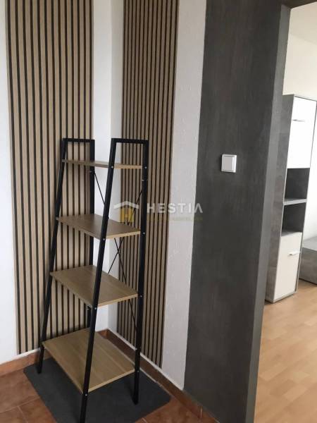 NOVINKA Prenájom 2 izbového bytu na Robotníckej ulici, voľný od 01.05. - Interiér 2-izbového bytu s policou a stenami s dreveným dekorom.