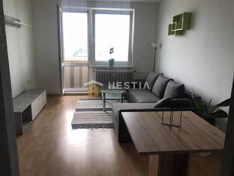 NOVINKA Prenájom 2 izbového bytu na Robotníckej ulici, voľný od 01.05. - Obývacia izba v 2-izbovom byte s podlahou s dreveným dekorom a pohovkou.