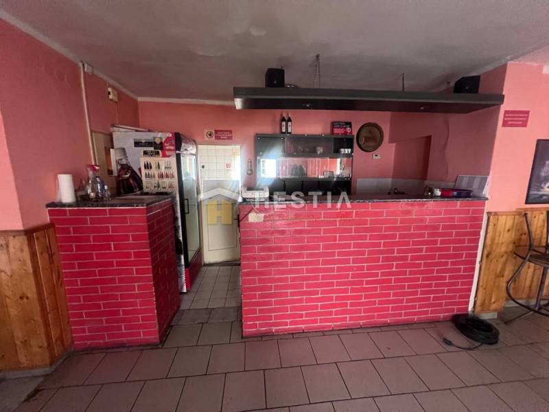 Na predaj rodinný dom, gastro prevádzka – Senica, Robotnícka ulica - Gastro priestory s tehlovým barom, podlaha s dreveným dekorom, steny s ružovým náterom.