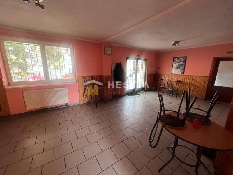 Na predaj rodinný dom, gastro prevádzka – Senica, Robotnícka ulica - Gastro priestory s tehlovou podlahou, dreveným dekorom na stenách a stolmi.