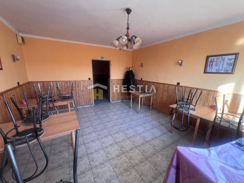 Na predaj rodinný dom, gastro prevádzka – Senica, Robotnícka ulica - Oranžovo ladené gastro priestory s kachličkovou podlahou, stoly s obrátenými stoličkami.