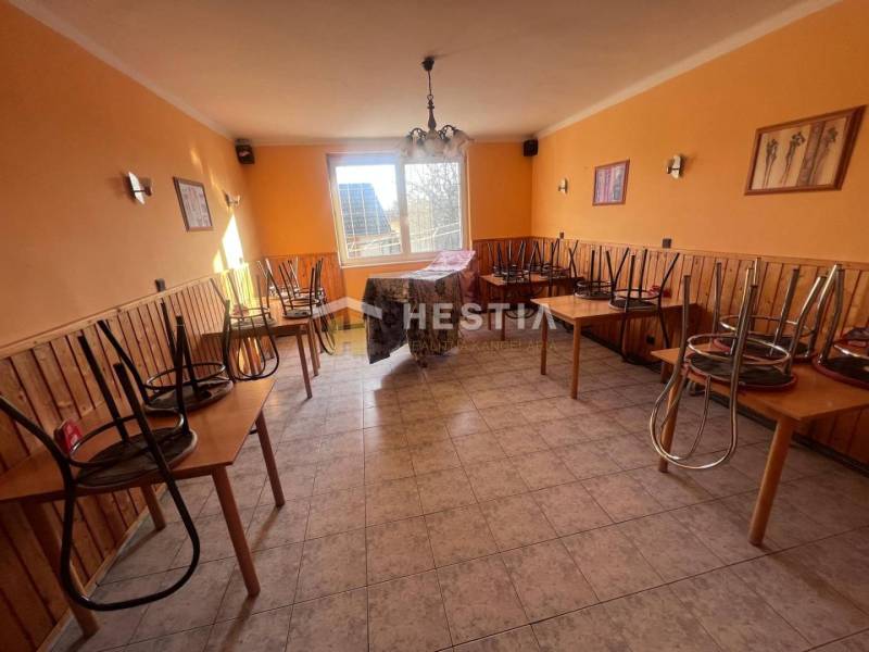 Na predaj rodinný dom, gastro prevádzka – Senica, Robotnícka ulica - Gastro priestory s dlažbou, stoličky na stoloch, oranžové steny a okno do dvora.