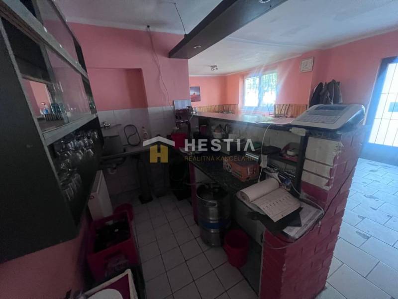 Na predaj rodinný dom, gastro prevádzka – Senica, Robotnícka ulica - Interiér gastro priestorov s barovým pultom, pokladňou a pohármi na poličke.