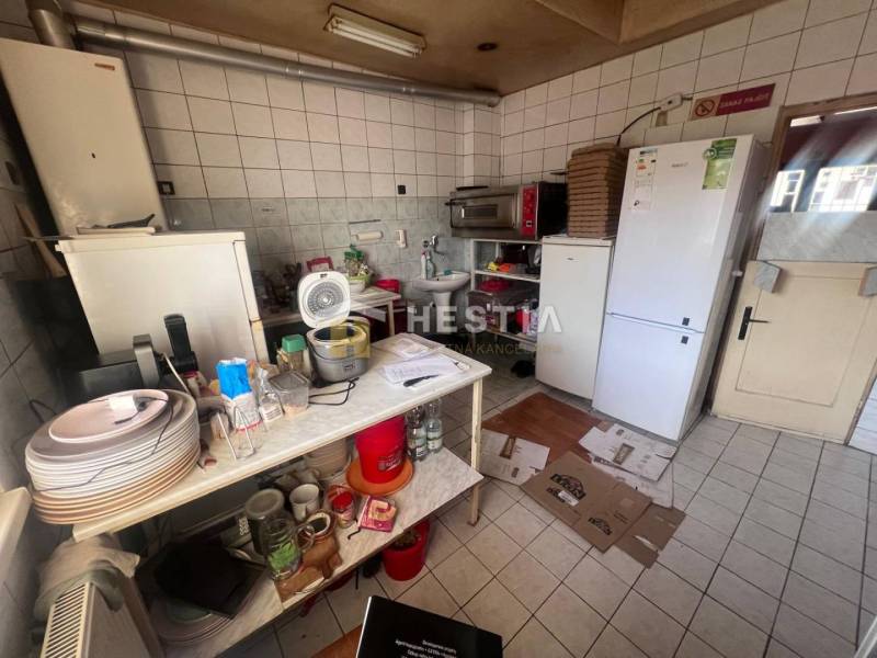 Na predaj rodinný dom, gastro prevádzka – Senica, Robotnícka ulica - Kuchyňa s gastro priestormi, biela dlažba, zásobníky, kuchynské potreby, ventilátor, chladničky.