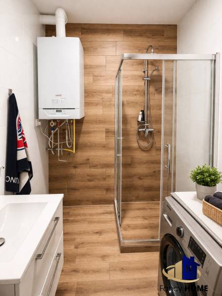 Moderný 2-izbový byt v centre Kežmarku na predaj - Kúpeľňa v 2-izbovom byte s podlahou s dreveným dekorom a sprchovacím kútom.