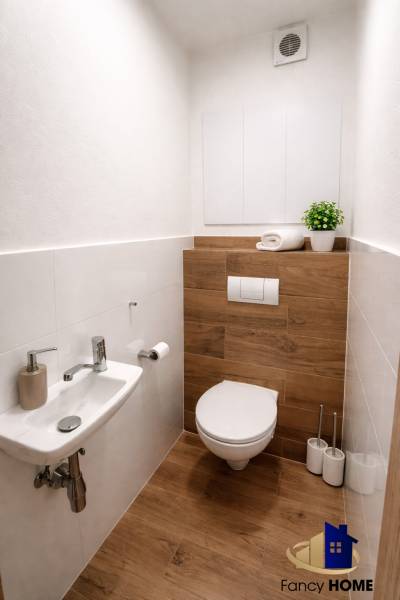 Moderný 2-izbový byt v centre Kežmarku na predaj - Kúpeľňa s toaletou v 2-izbovom byte, podlaha s dreveným dekorom, jednoduchý dizajn.
