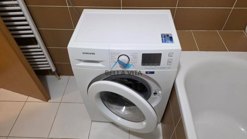 Prenájom 1 izbový byt v Galante, Hodská - Práčka Samsung vedľa vane a rebríkového radiátora v 1-izbovom byte.