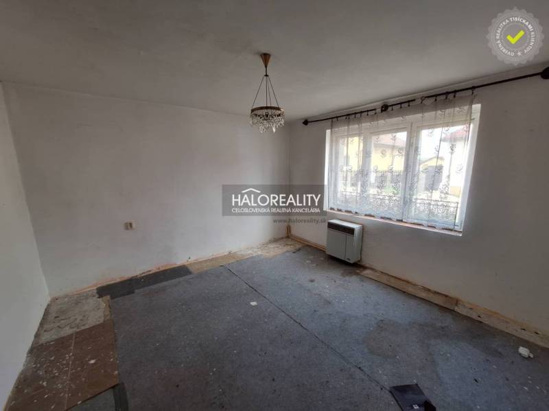 Predaj, pozemok pre rodinný dom   1468 m2 Dvorníky -... - Izba s kobercom, bielymi stenami a veľkým oknom, vhodná na rekonštrukciu; Pozemky - bývanie.