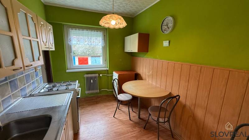Na predaj 3i byt Pukanec - Kuchyňa v 3-izbovom byte s podlahou s dreveným dekorom a zelenými stenami.