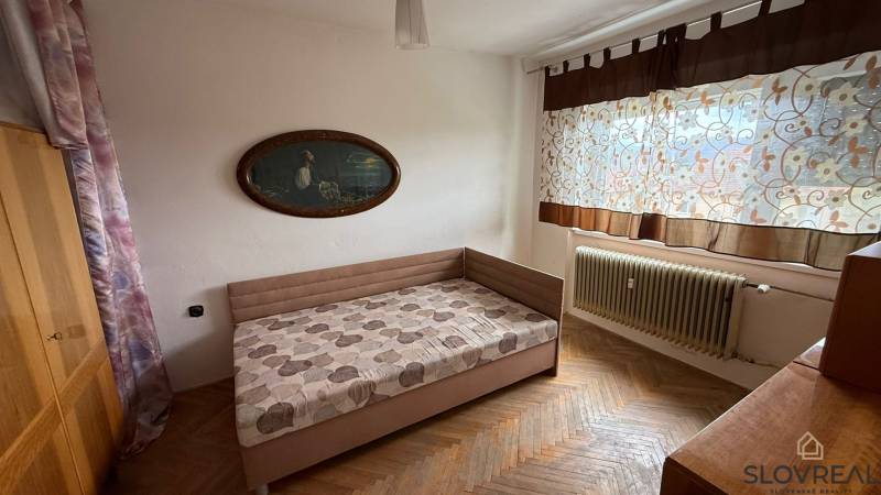 Na predaj 3i byt Pukanec - Spálňa v 3-izbovom byte s posteľou, obrazom a podlahou s dreveným dekorom.