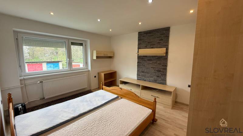 Na predaj 3i byt Pukanec - Spálňa s kamenným obkladom a podlahou s dreveným dekorom v 3-izbovom byte.
