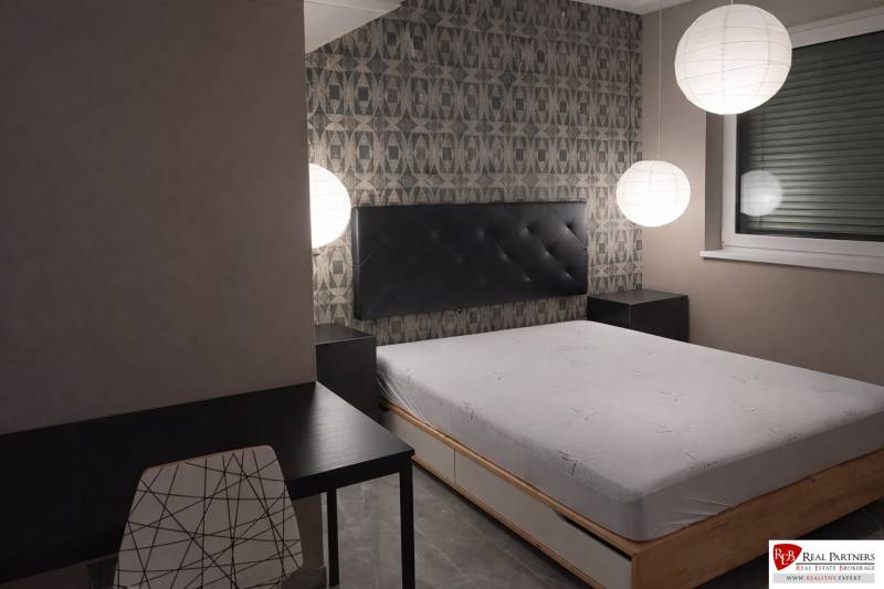 Predaj 2-izbový byt GREEN VILLAGE,44m2, loggia, Dunajská Lužná - Spálňa s posteľou, večerné osvetlenie, stolík a stolička v 2-izbovom byte.