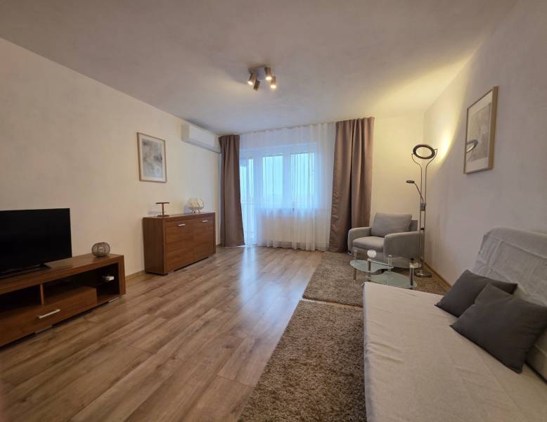 PRENÁJOM - Priestranný 3 izbový byt - Nitra, Centrum - Obývacia izba v 3-izbovom byte s podlahou s dreveným dekorom a pohodlným nábytkom.