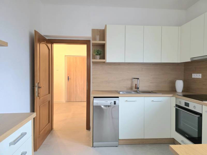 PRENÁJOM - Priestranný 3 izbový byt - Nitra, Centrum - Svetlá kuchyňa so vstavanými spotrebičmi a podlahou s dreveným dekorom v 3-izbovom byte.