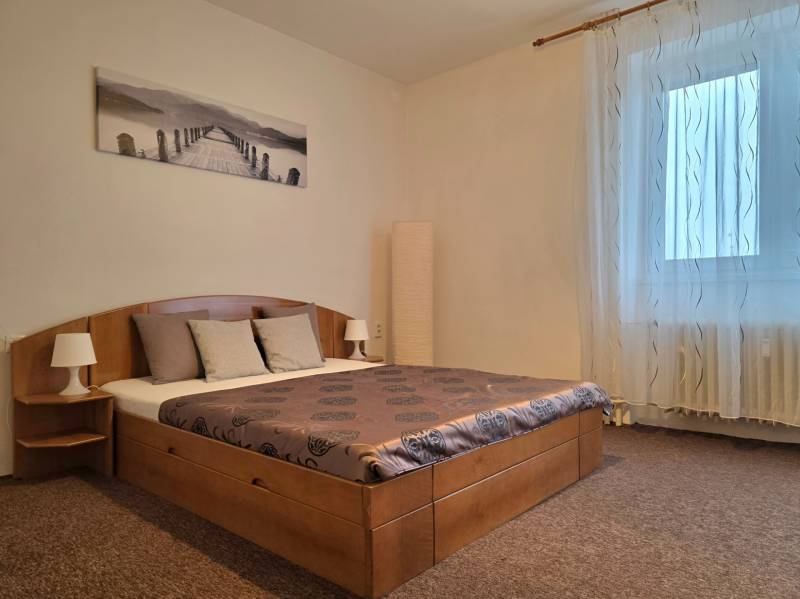 PRENÁJOM - Priestranný 3 izbový byt - Nitra, Centrum - Spálňa v 3-izbovom byte s posteľou, obrazom, nočnými lampami a závesmi.