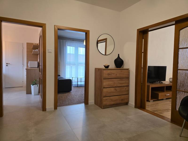 PRENÁJOM - Priestranný 3 izbový byt - Nitra, Centrum - Interiér 3-izbového bytu s priestrannou chodbou, zásuvkami a podlahou s dreveným dekorom.