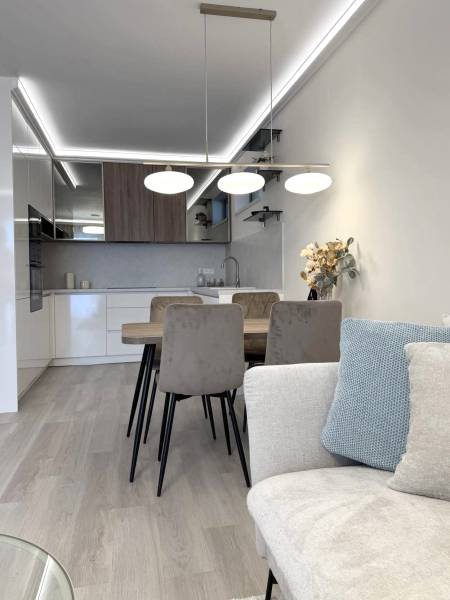 2 izbový A.3.1.- 58,91 m2 Bell Residence  - Svetlá kuchyňa s jedálenským stolom v 2-izbovom byte s podlahou s dreveným dekorom.