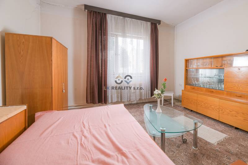 Na predaj rodinný dom Trnava, Zelenečská ulica, pozemok 1085 m2 - Interiér rodinného domu so skleneným stolíkom, nábytkom a záclonami.