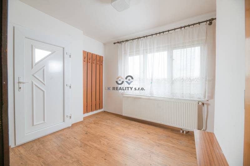 Na predaj rodinný dom Trnava, Zelenečská ulica, pozemok 1085 m2 - Interiér rodinného domu s bielymi stenami, oknami a podlahou s dreveným dekorom.