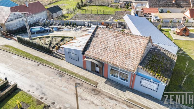 Komerčný objekt s pozemkom – možnosť zmeny na rodinný dom - Obchodné priestory v Okoči s tradičnou strechou, chodníkom a záhradou.