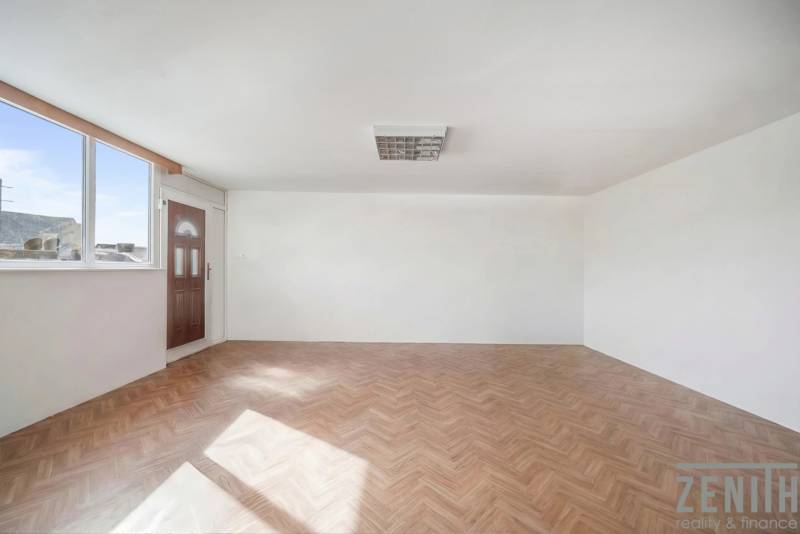 Komerčný objekt s pozemkom – možnosť zmeny na rodinný dom - Priestranné obchodné priestory s veľkým oknom a podlahou s dreveným dekorom.