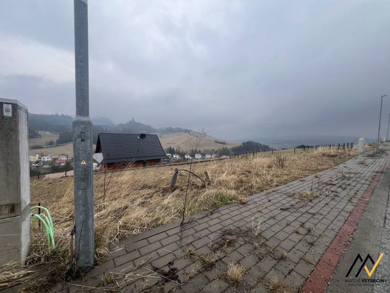 STAVEBNÝ POZEMOK | STARÁ ĽUBOVŇA - ŠIBENIČNÁ HORA - Pohľad na pozemky - bývanie v Starej Ľubovni s viditeľným chodníkom a domom.