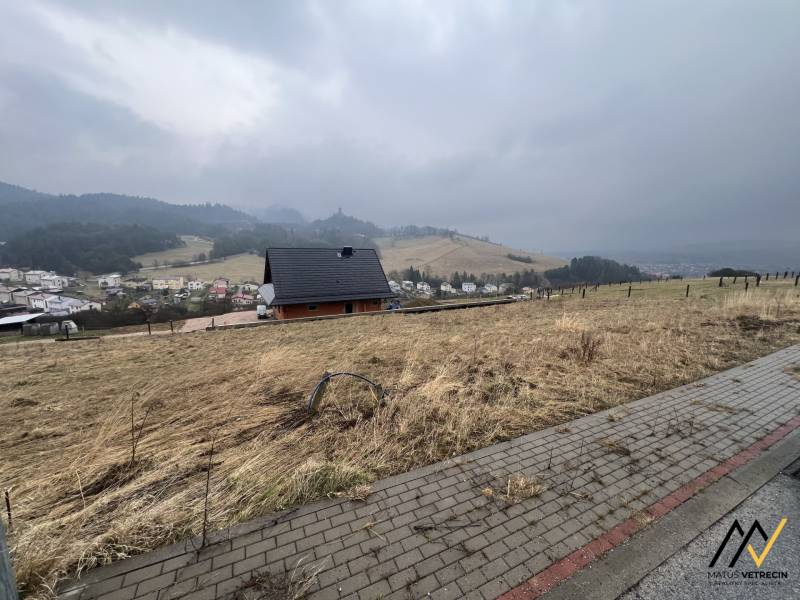 STAVEBNÝ POZEMOK | STARÁ ĽUBOVŇA - ŠIBENIČNÁ HORA - Kopcovitý výhľad z pozemkov na bývanie v Starej Ľubovni s domom a stromami.