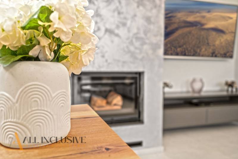 ALL INCLUSIVE I PERFEKTNÝ 4- IZBOVÝ RD SMART HOME - MOSTOVÁ (GA) - Váza s kvetmi na stole, podlaha s dreveným dekorom, krb v rodinnom dome.