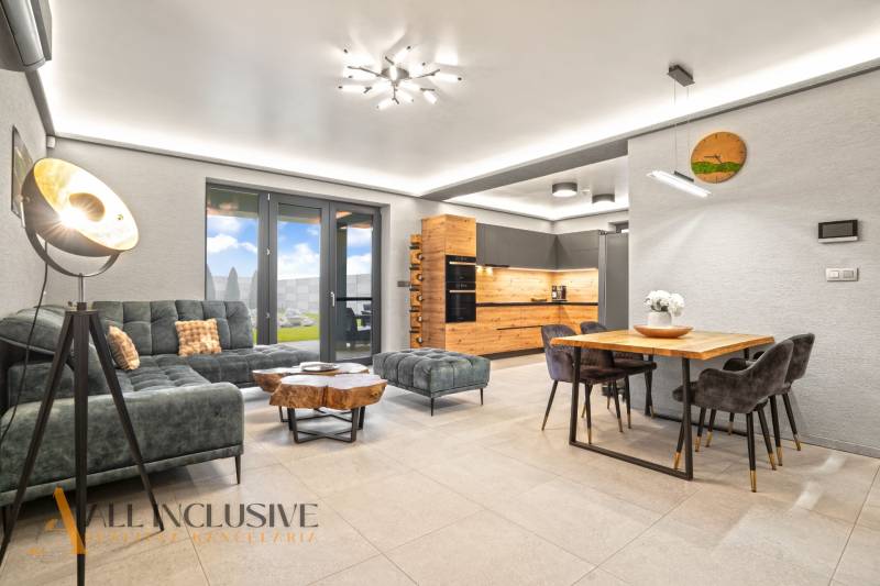 ALL INCLUSIVE I PERFEKTNÝ 4- IZBOVÝ RD SMART HOME - MOSTOVÁ (GA) - Obývačka s kuchyňou v rodinnom dome, podlaha s dreveným dekorom, pohovka a stolík.