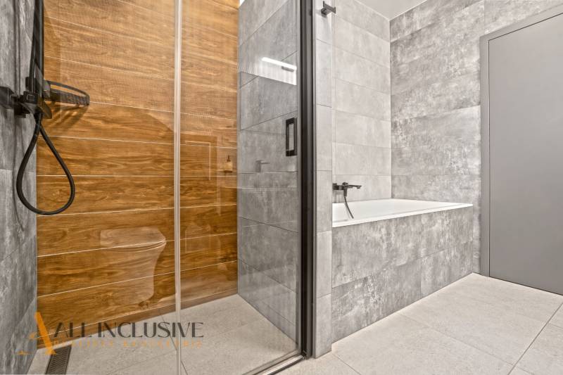 ALL INCLUSIVE I  4- IZBOVÝ RD SMART HOME NOVOSTAVBA- MOSTOVÁ (GA) - Kúpeľňa v rodinnom dome s vaňou, skleným sprchovacím kútom a podlahou s dreveným dekorom.