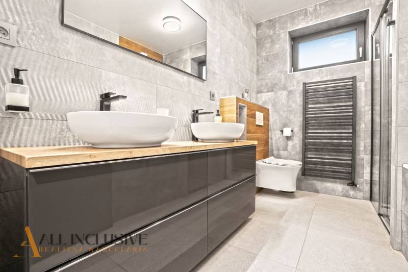 ALL INCLUSIVE I  4- IZBOVÝ RD SMART HOME NOVOSTAVBA- MOSTOVÁ (GA) - Kúpeľňa v rodinnom dome, šedé obklady, dve umývadlá, sprchový kút, drevený dekor.
