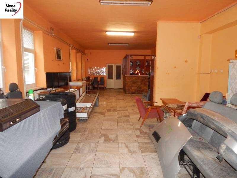  Podnikateľská príležitosť v obci Búč . - Interiér gastro priestorov s oranžovými stenami, skladový priestor so stoličkami a vybavením.