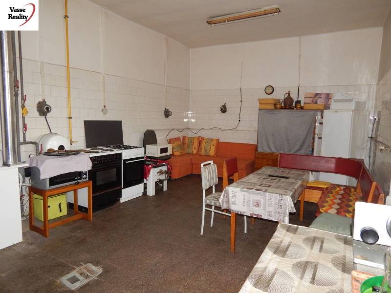  Podnikateľská príležitosť v obci Búč . - Interiér gastronomických priestorov s vybavenou kuchyňou a sedačkou, podlaha s dreveným dekorom.