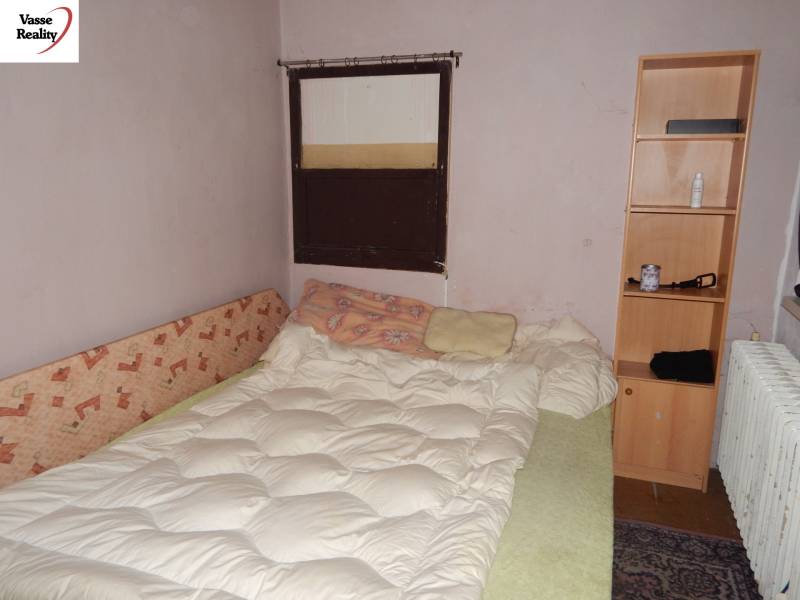  Podnikateľská príležitosť v obci Búč . - Izba s posteľou, regálom a radiátorom, vhodné pre gastro priestory na renováciu.