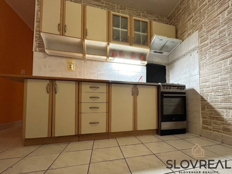 Na predaj 2i byt Levice - Kuchyňa v 2-izbovom byte s dlažbou a dreveným dekorom na linke.