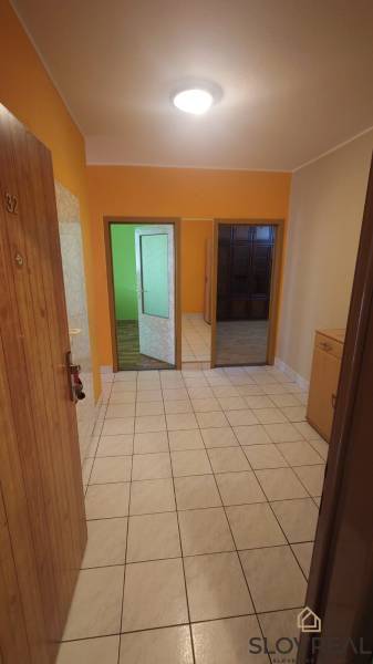 Na predaj 2i byt Levice - Chodba v 2-izbovom byte s dlažbou a otvárajúcimi sa dverami do ďalších miestností.