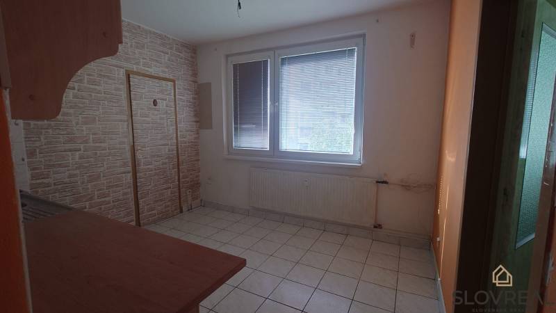 Na predaj 2i byt Levice - Izba s dlažbou, veľkým oknom a radiátorom v 2-izbovom byte.