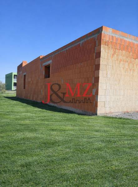 Na predaj výnimočný átriový rodinný dom s dvojgarážou v obci Dolná Seč - Nedokončená stavba rodinného domu v Dolnej Seči obklopená upraveným trávnikom.