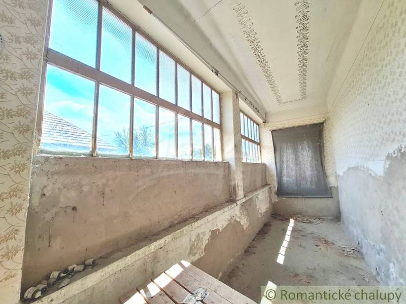 Rozľahlý pozemok so starým domom v obci Kamenný Most blízko Štúrova - Chata v Kamennom Moste s dlhou veranda a veľkými oknami, potrebuje renováciu.