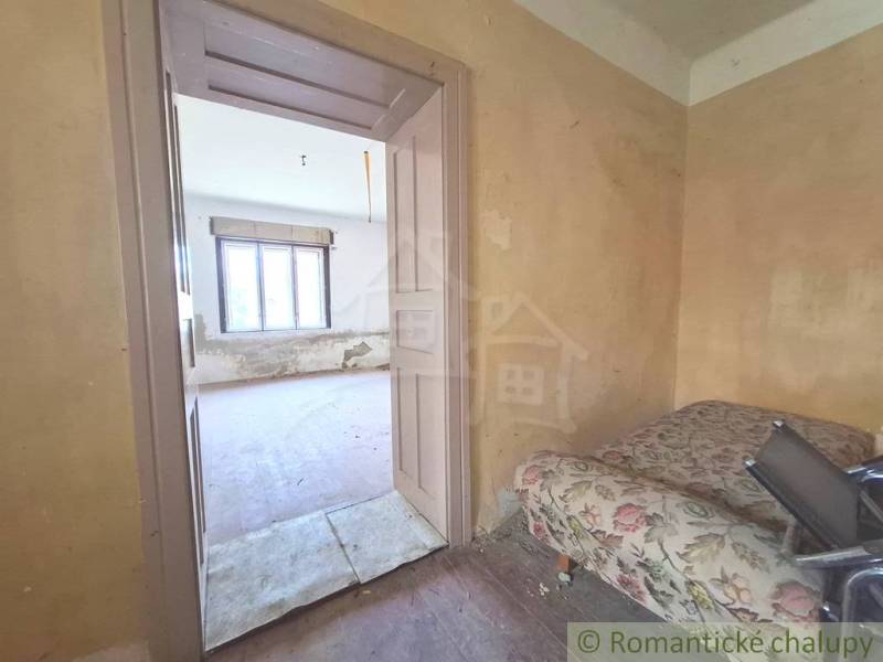 Rozľahlý pozemok so starým domom v obci Kamenný Most blízko Štúrova - Izba na chate so starým nábytkom a oknom, čaká na renováciu.