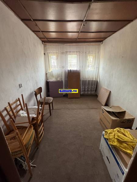 Rodinný dom Martin - Valča - Jednoduchá izba s kartónmi a drevenými stoličkami v rodinnom dome.