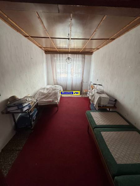 Rodinný dom Martin - Valča - Izba v rodinnom dome s červeným kobercom a posteľami na oboch stranách.