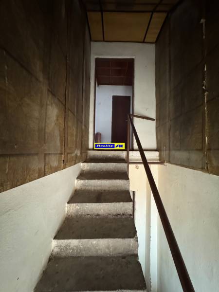 Rodinný dom Martin - Valča - Schodisko v rodinnom dome s dreveným zábradlím vedúce na poschodie.