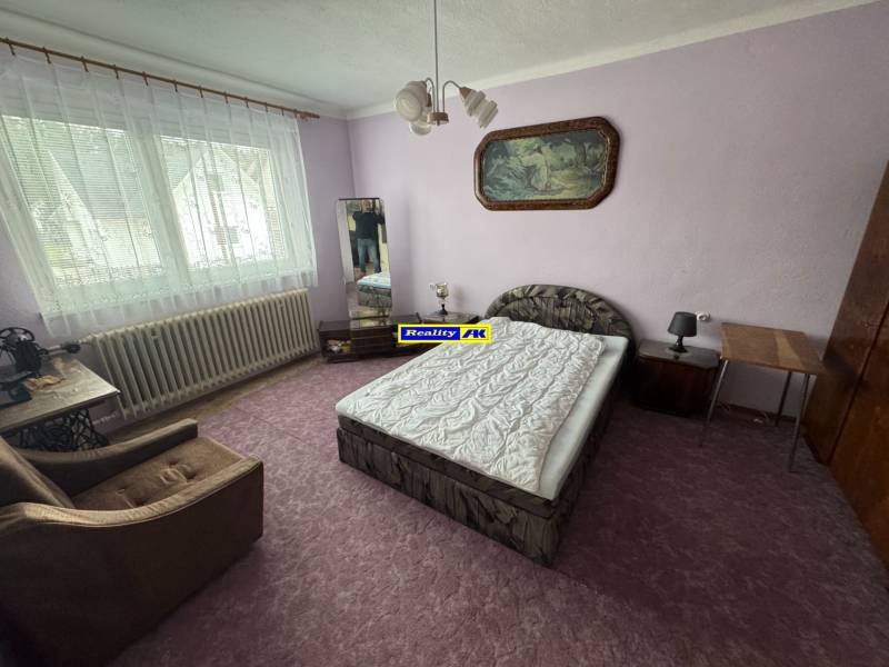 Rodinný dom Martin - Valča - Spálňa s posteľou, kreslom a obrazom v Rodinnom dome.