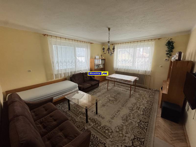 Rodinný dom Martin - Valča - Obývacia izba s klasickým zariadením, kobercom a pohovkou v rodinnom dome.